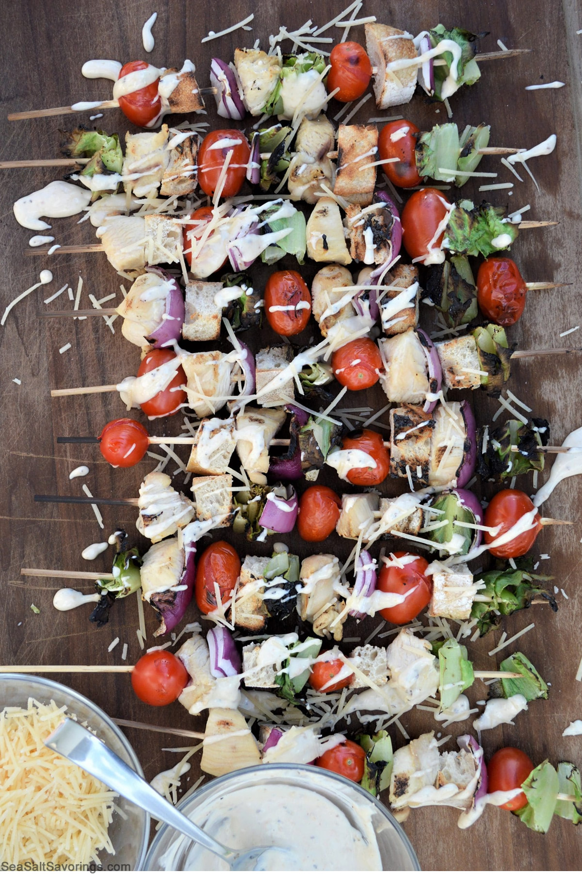 caesar skewers on a table with caesar dressing spattered on top