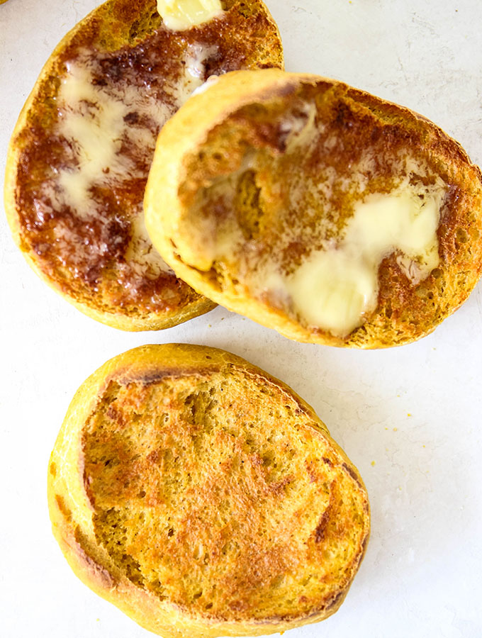 cooked muffins cut in half with butter