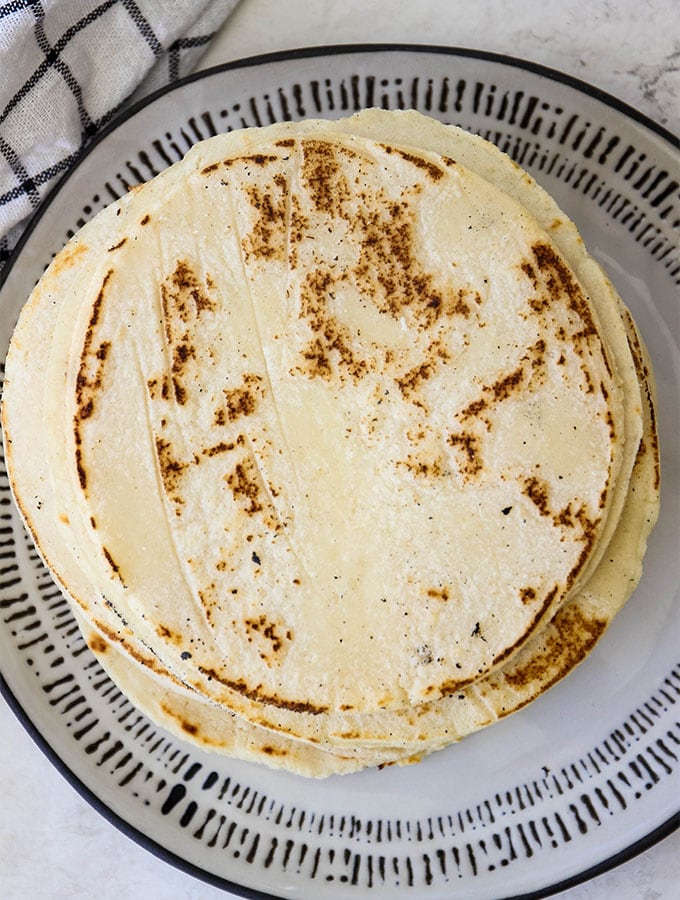 cooked tortillas stacked on a plate