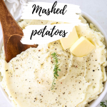 Mashed potatoes are plated in a white bowl with a wooden spoon digging in.