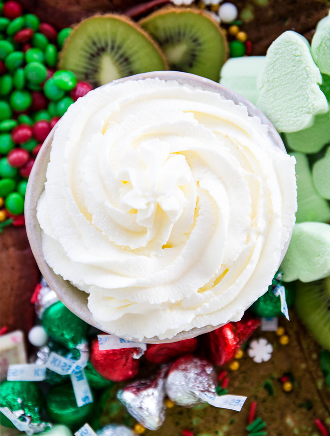 Whipped cream is made from scratch with simple ingredients and plated in a white bowl.