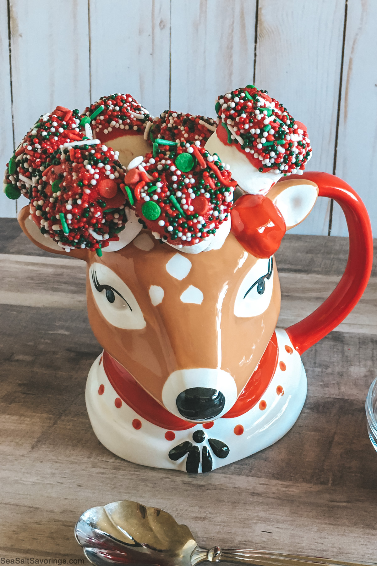 reindeer coffee cup with dipped marshmallows on sticks placed inside