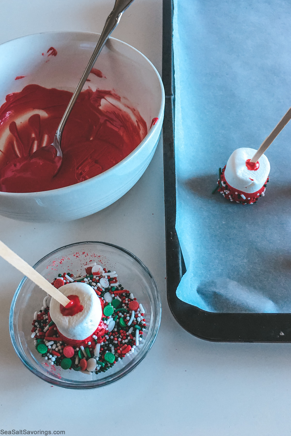 dipping marshmallows on sticks in toppings