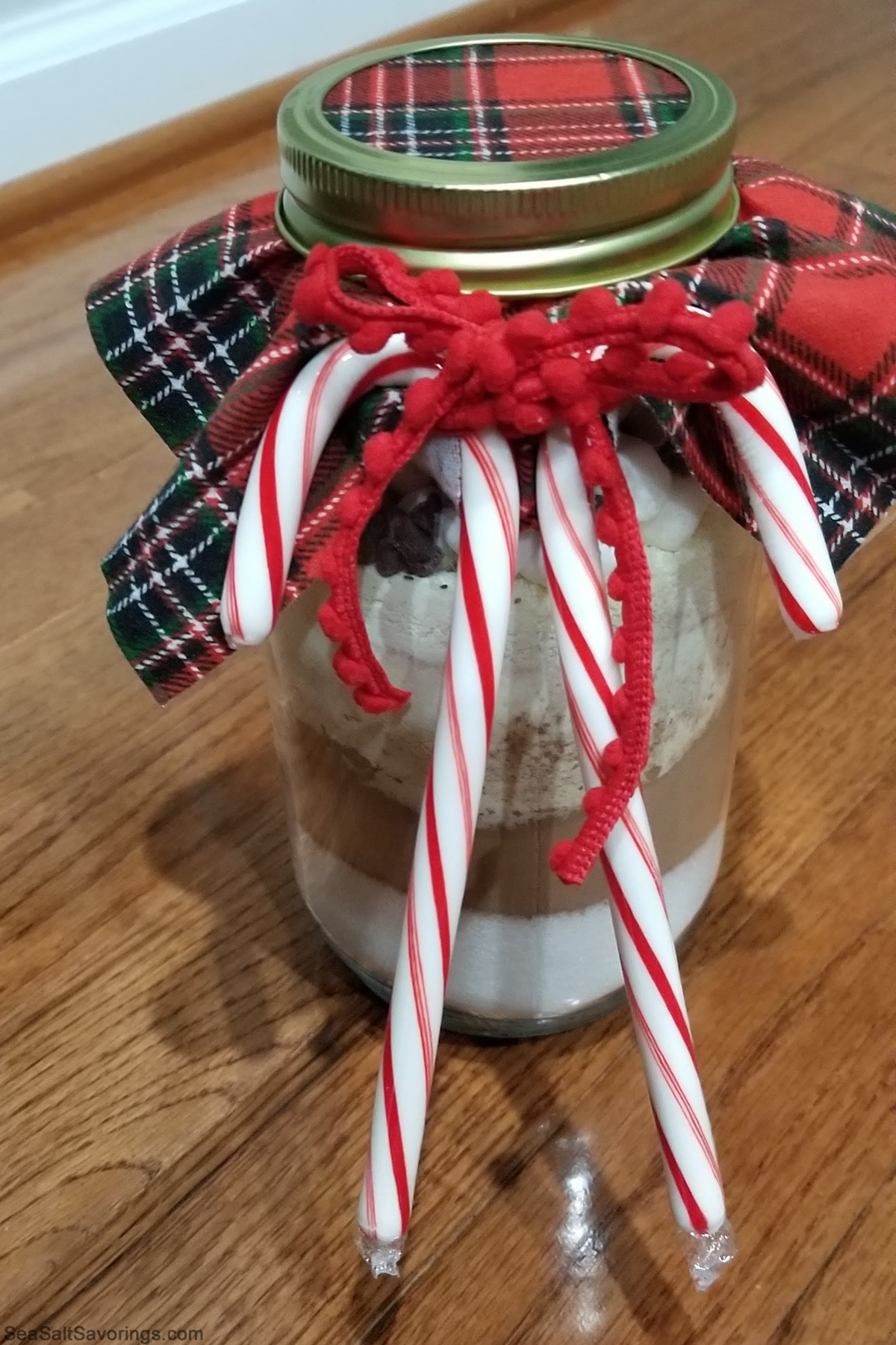 decorated hot cocoa jar with candy canes affixed to it