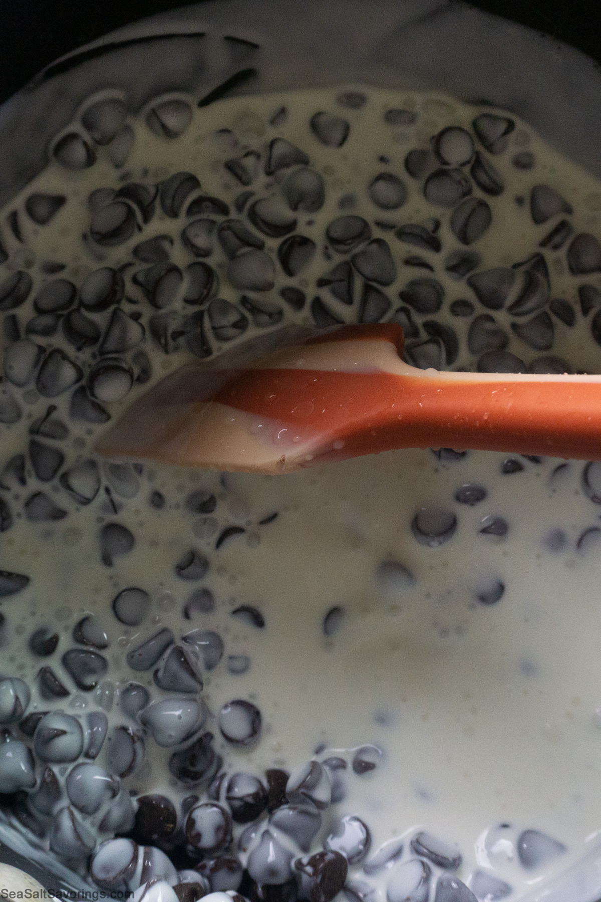 chocolate chips in milk getting stirred and cooked