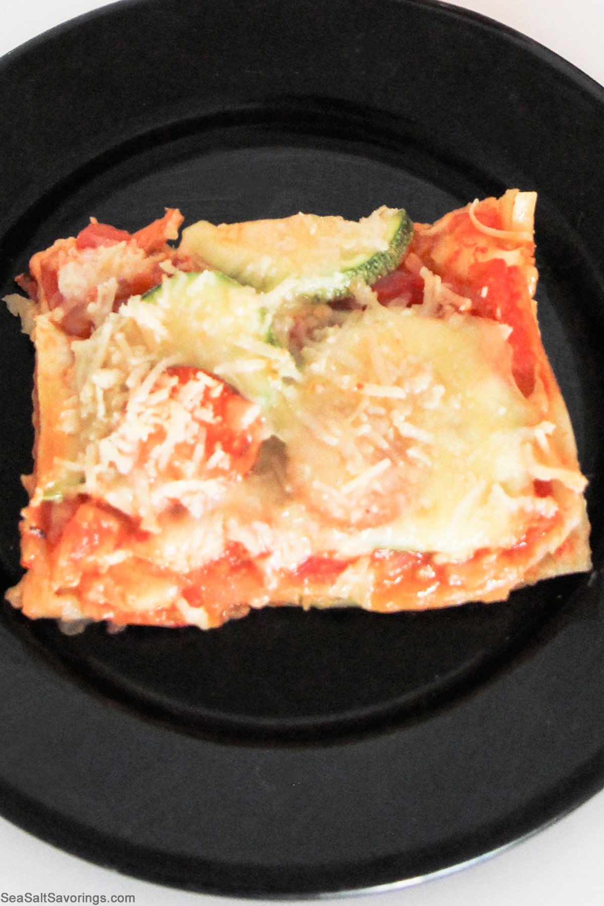 black plate with slice of vegetable lasagna