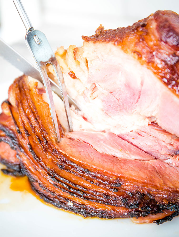 The spiral ham is cut with a sharp knife and large fork.
