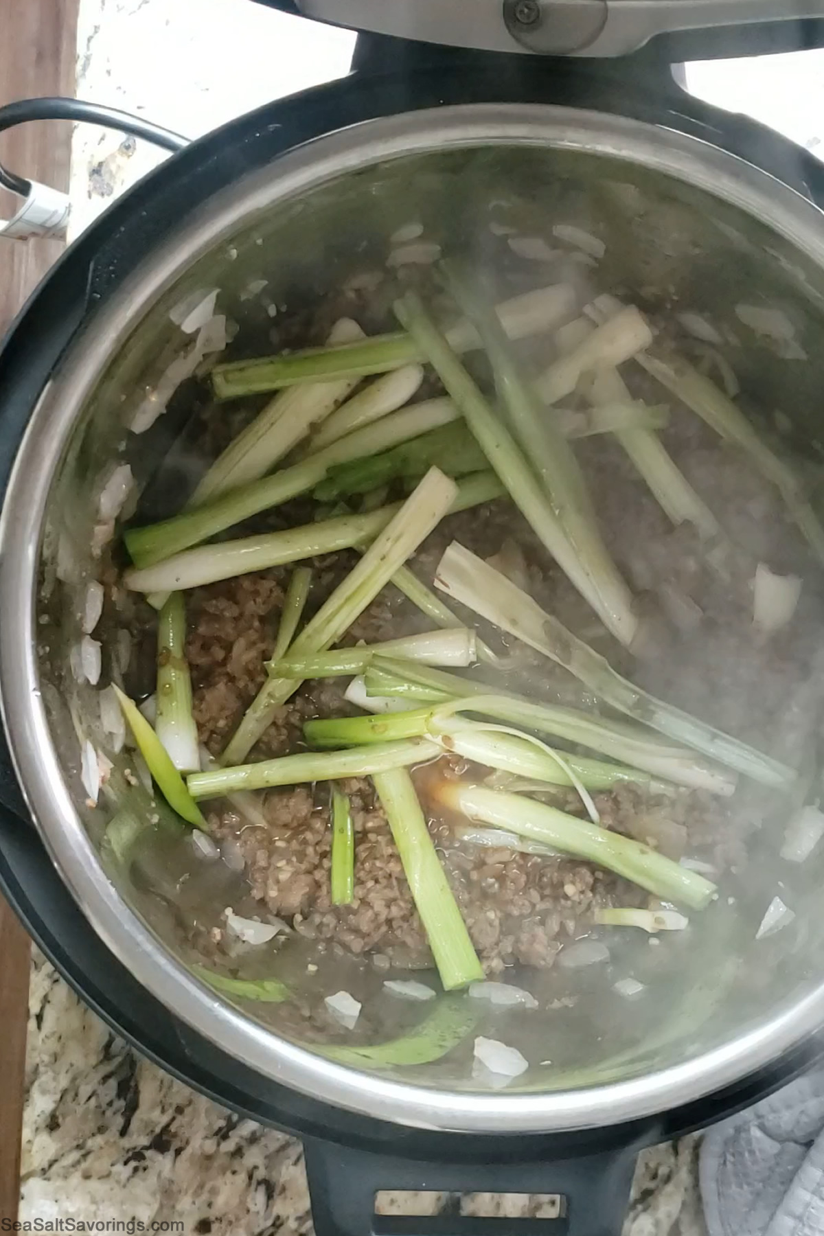 inside an instant pot as beef and vegetables are cooking