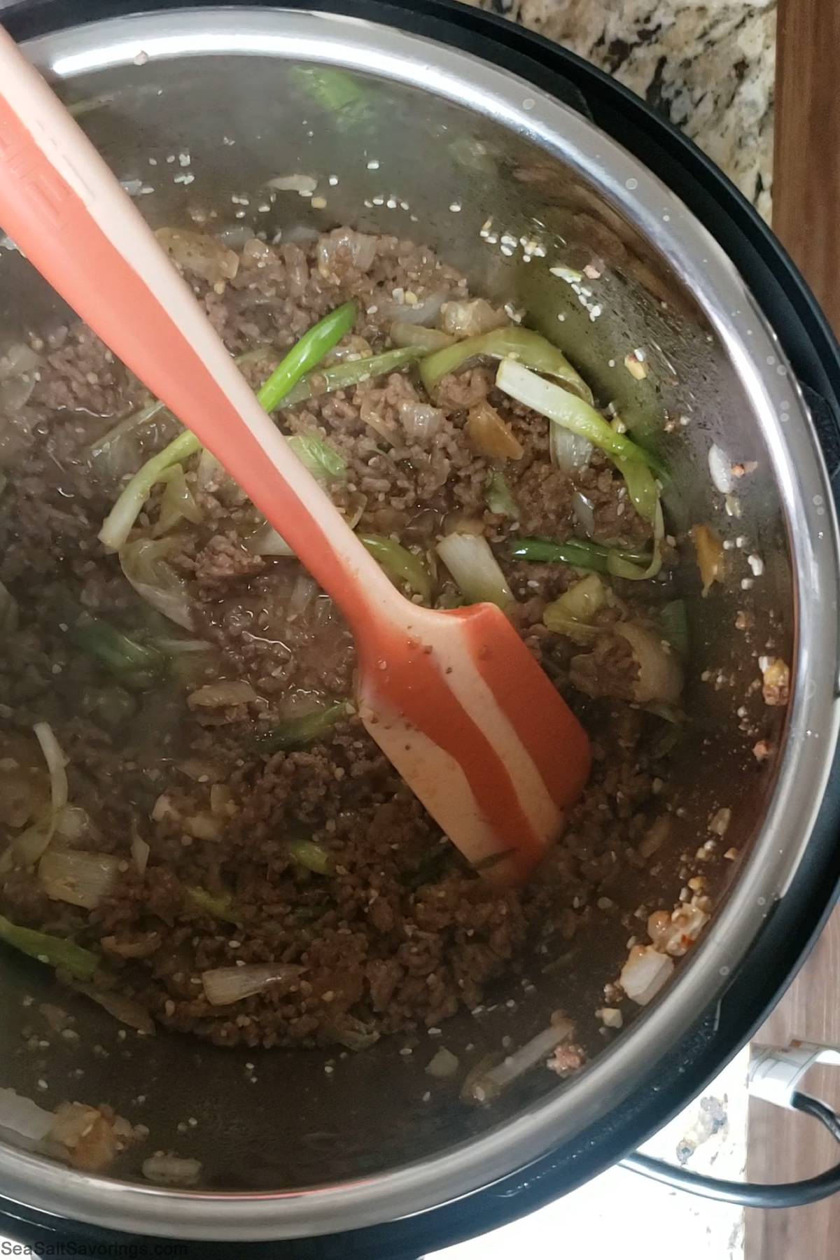 inside instant pot stirring sauce and beef and vegetables