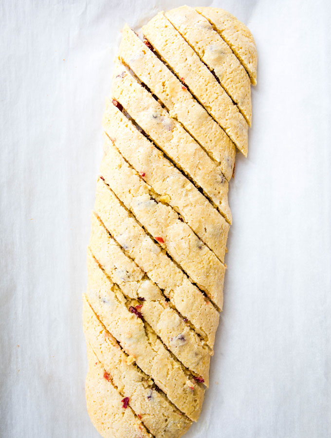 A loaf of biscotti dough is baked, then cut into slices to be baked again.