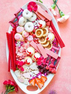 Valentine's day treats are plated on a charcuterie board.