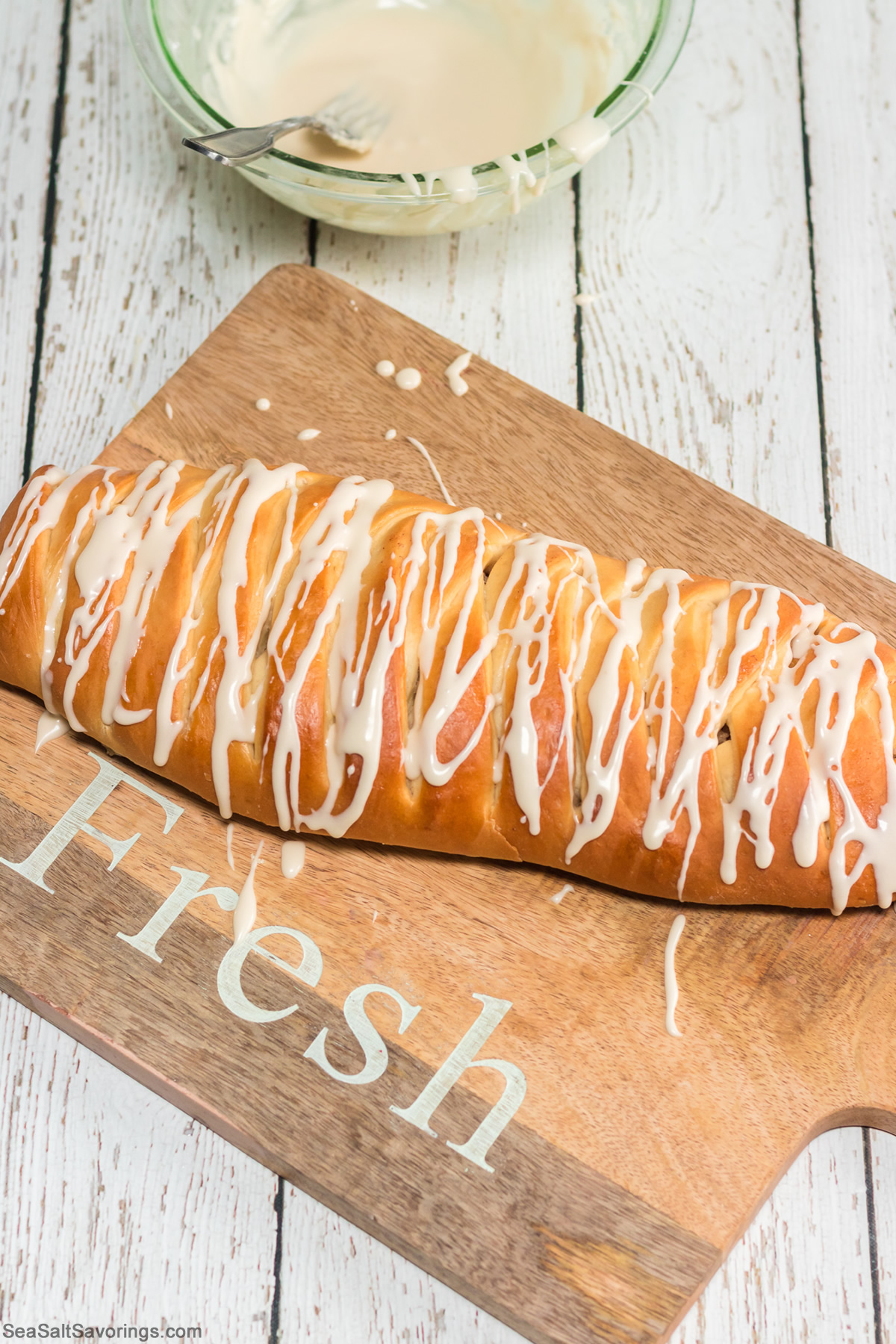 fresh loaf of apple bread with frosting drizzled on top