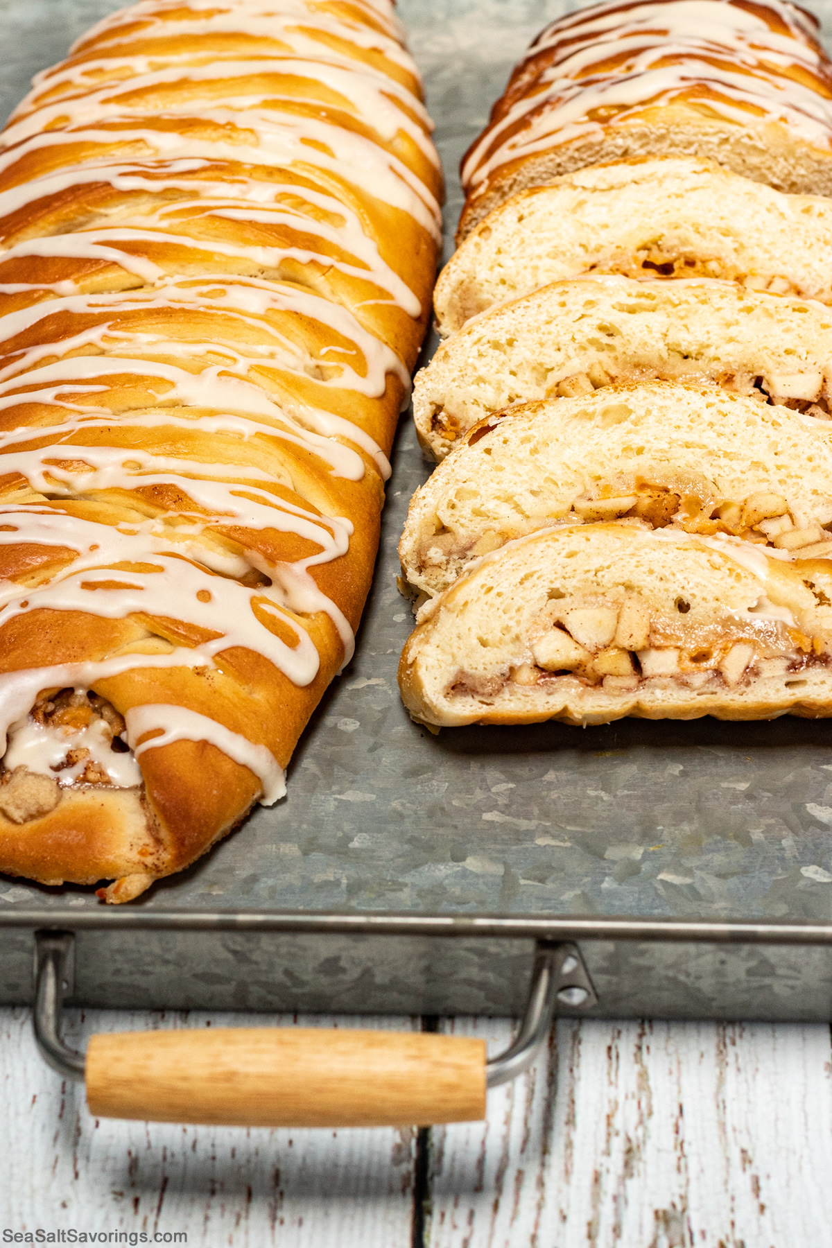 serving platter with two loafs of apple bread, one is sliced to show details of filling