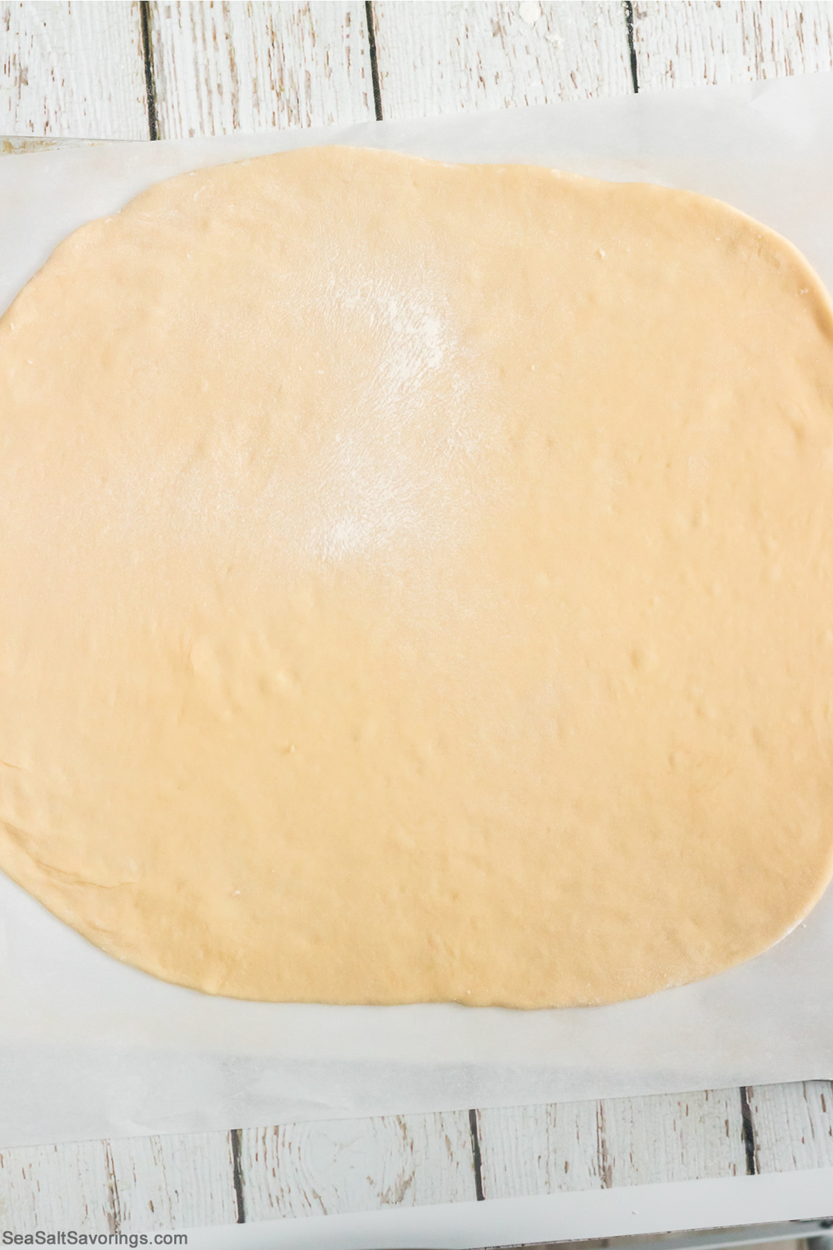 dough ball flattened out into a square sheet