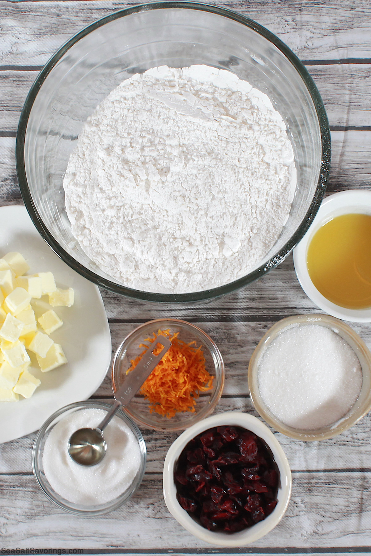 simple ingredients for cranberry orange cookies in bowls on a table