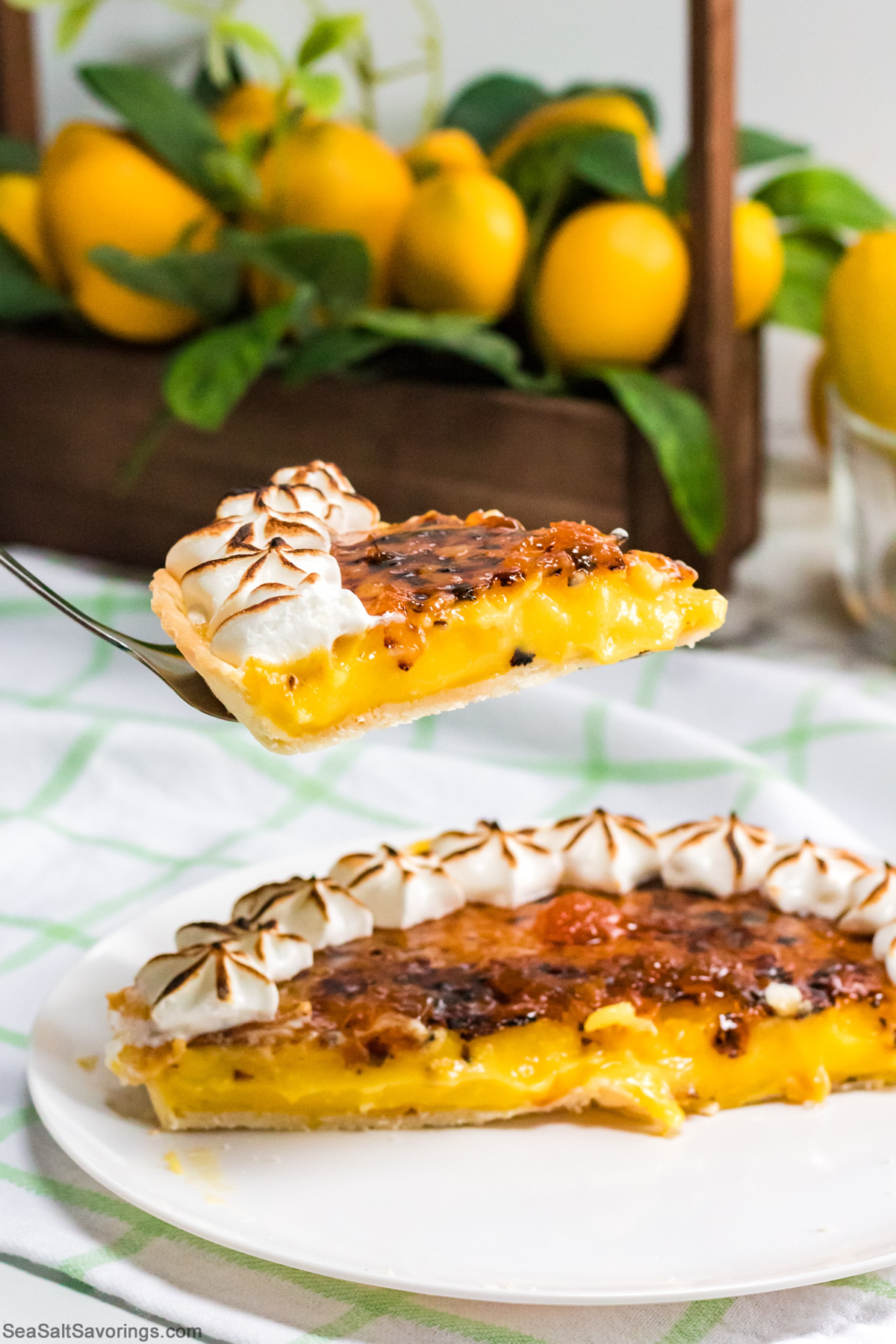 a slice of lemon custard tart being pulled from the whole pie