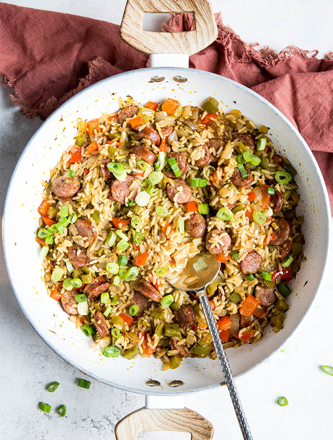 Cajun rice is made in one pot and stirred with a silver spoon.