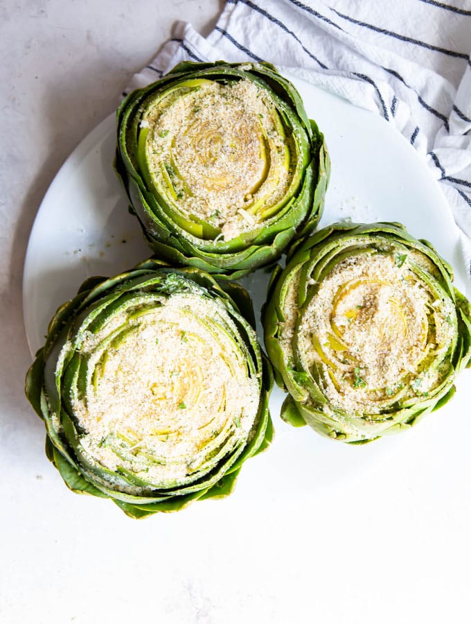 Artichokes are stuffed with the breadcrumb mixture before they are simmered on the stovetop.