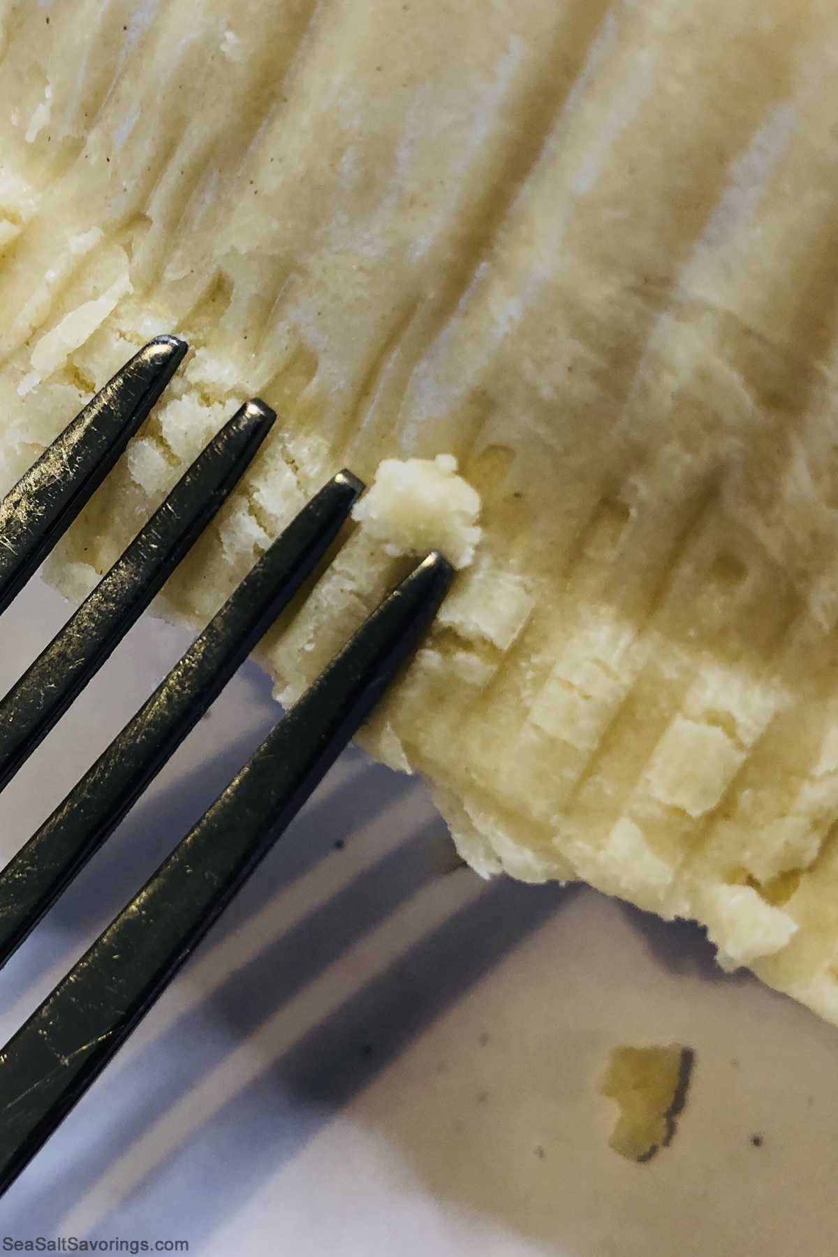 using a fork to crimp the edges of the two pie shells together