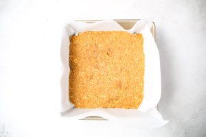 The vanilla wafer crust is pressed into a baking dish with the bottom of a cup.