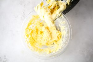 Cream cheese, sugar, pudding mix, and pineapple are mixed in a large mixing bowl.