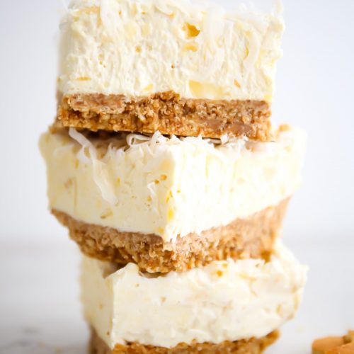 Cheesecake bars are stacked next to vanilla wafers.