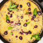 Blackberry cobbler is made in a cast iron pan and is topped with fresh mint.