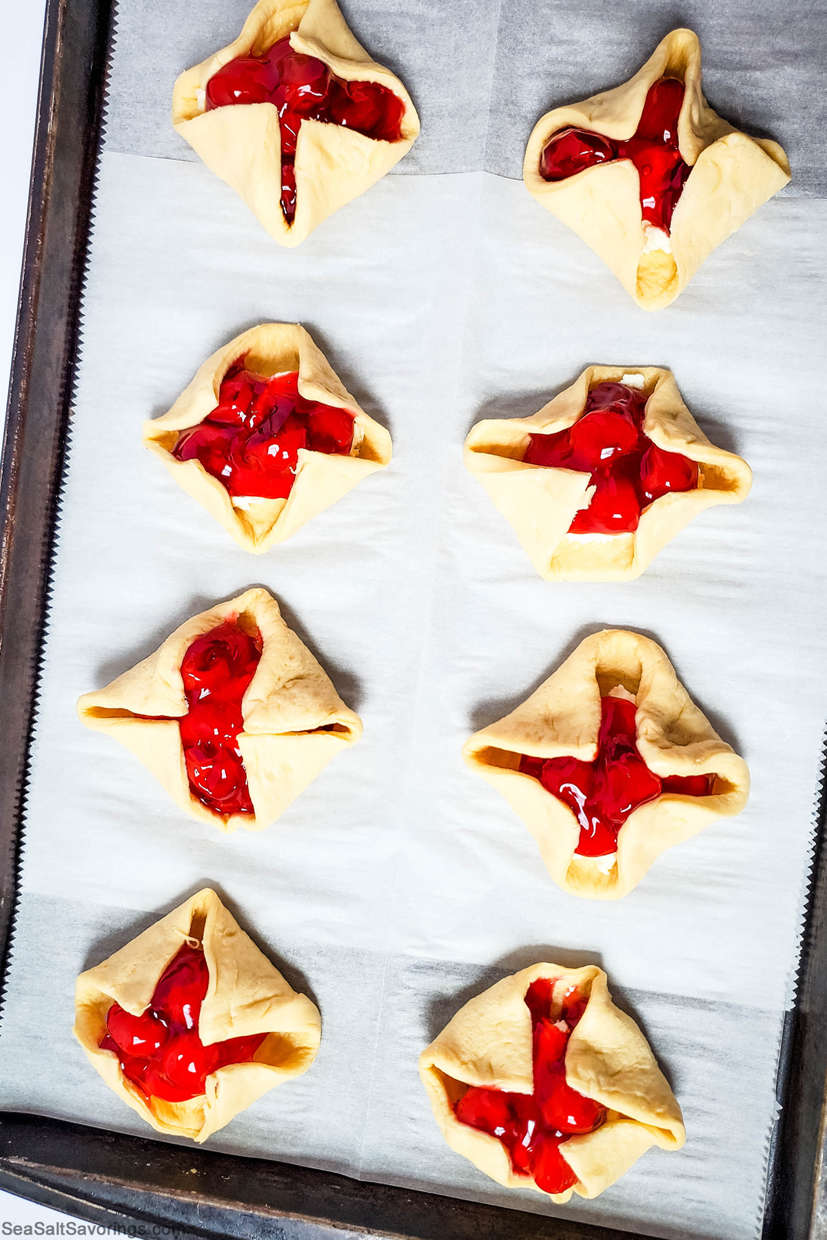 folding the edges of the dough up toward the top center of the pastries