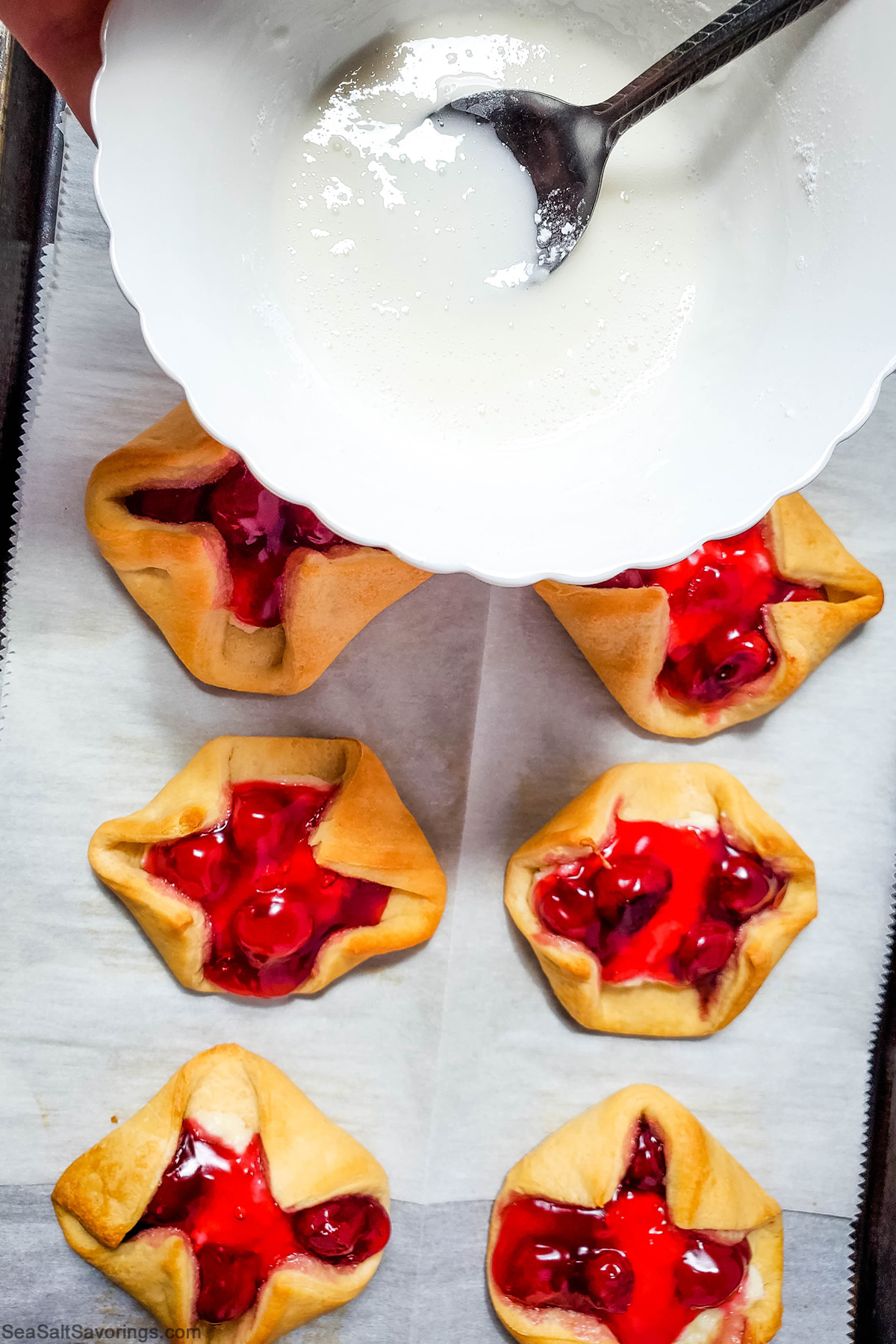 drizzling handmade frosting on top of the pastries