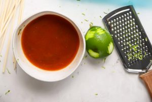 Sriracha sauce with honey and lime juice is made in one bowl.