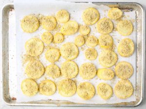 The summer squash is sliced, tossed in breading, and roasted in the oven.