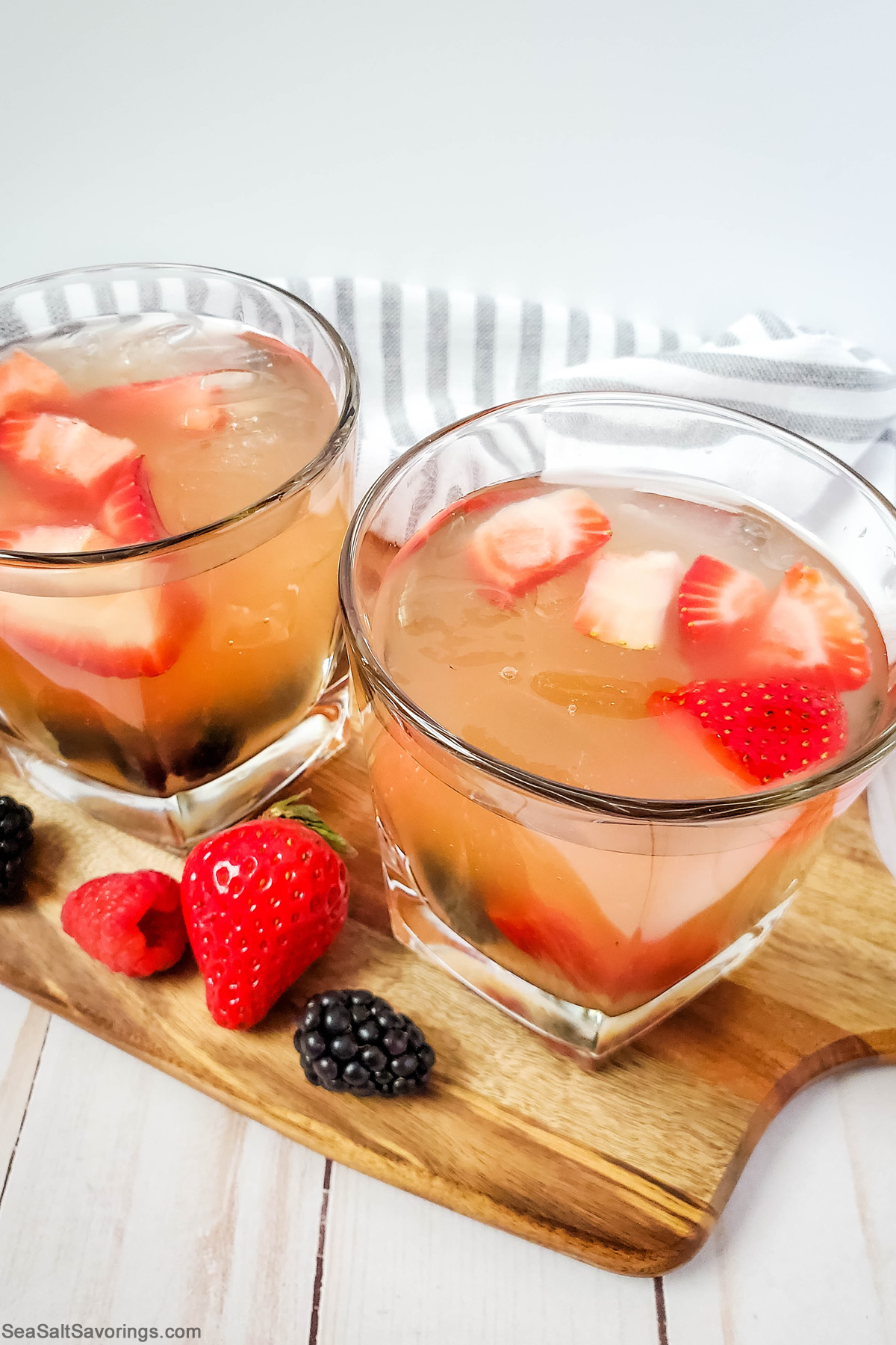 two glasses of sangria with chunks of strawberry floating