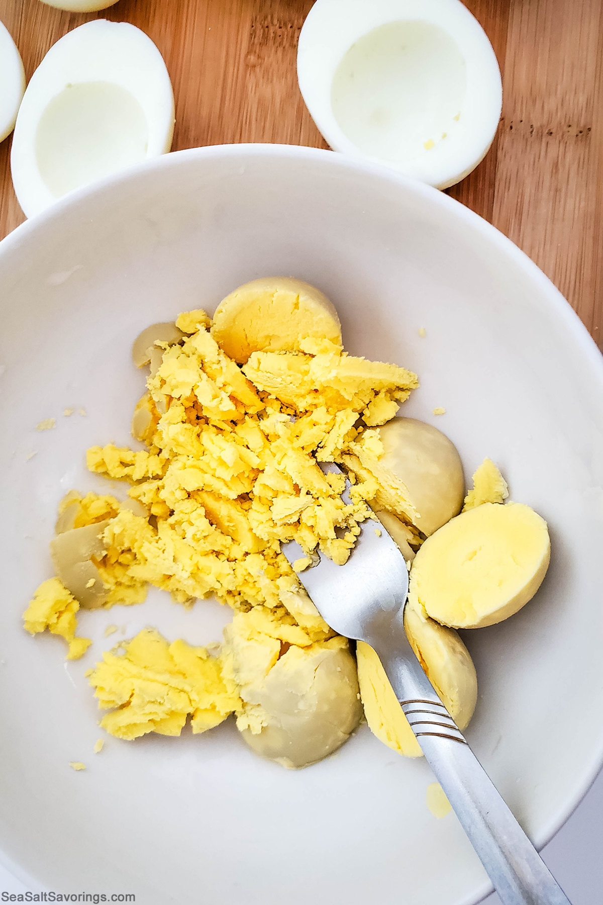 mashing egg yolk in a bowl