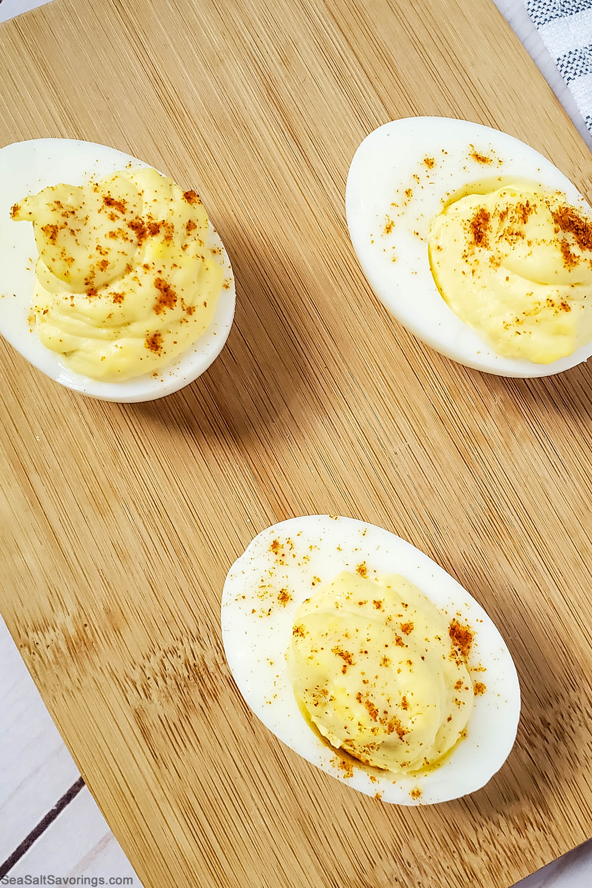 cutting board with 3 devilled eggs on it