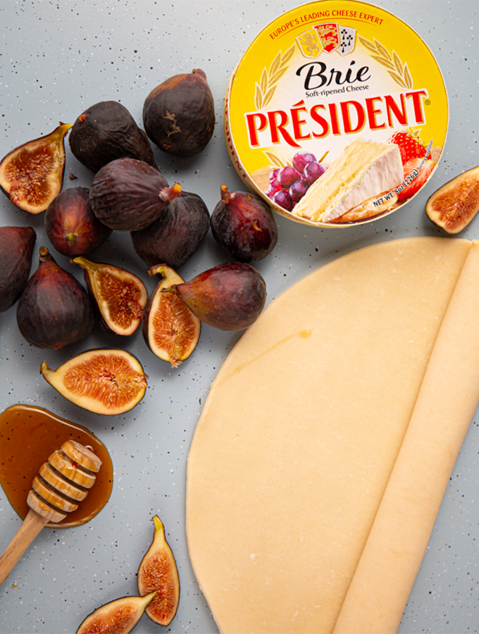 Fig and brie galete ingredients are displayed individually on a baking sheet.