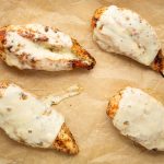 Mozzarella cheese is melted onto the seasoned chicken breasts.