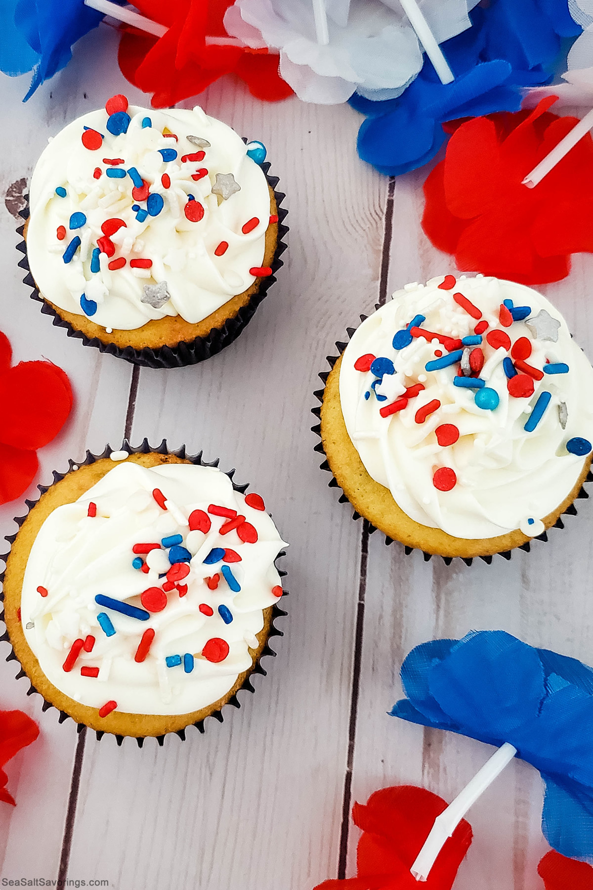 three cupcakes with festive red white and blue sprinkles on top