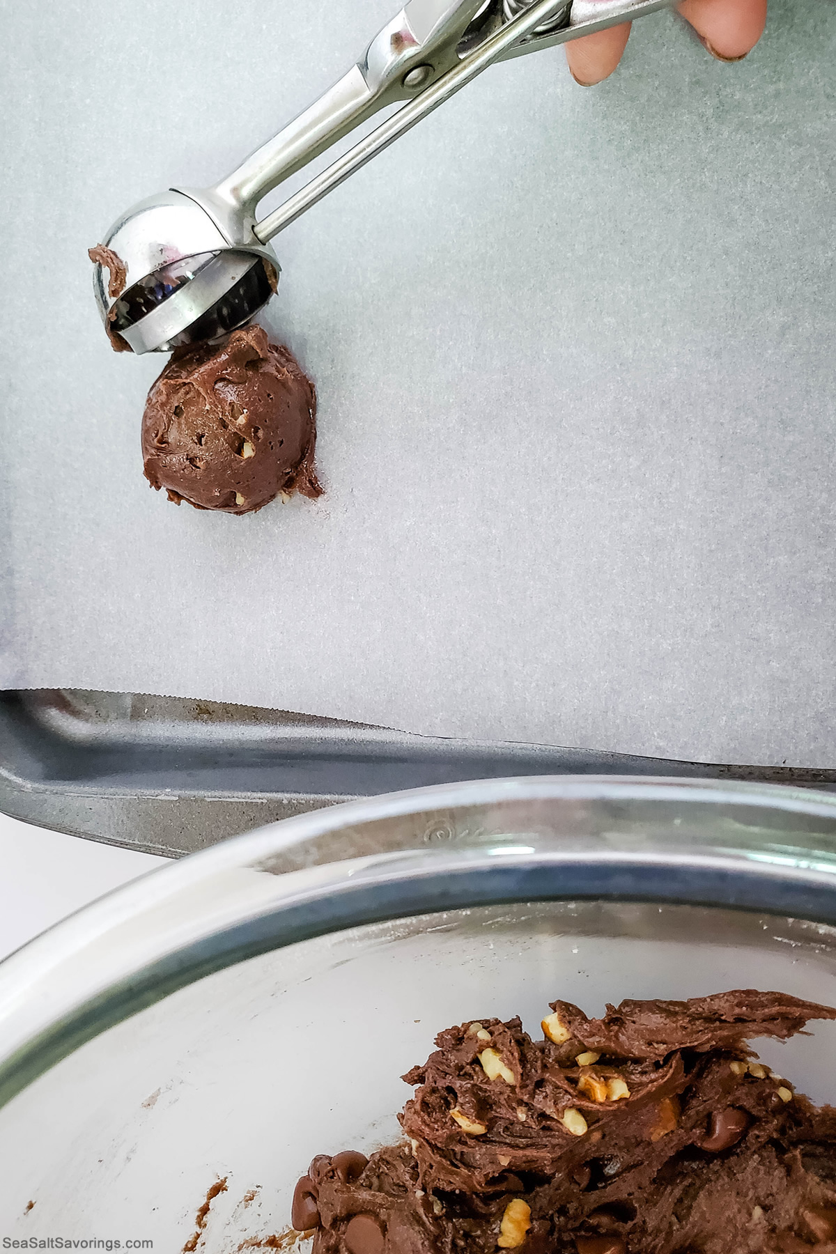 scooping balls of cookie dough onto a cooking sheet