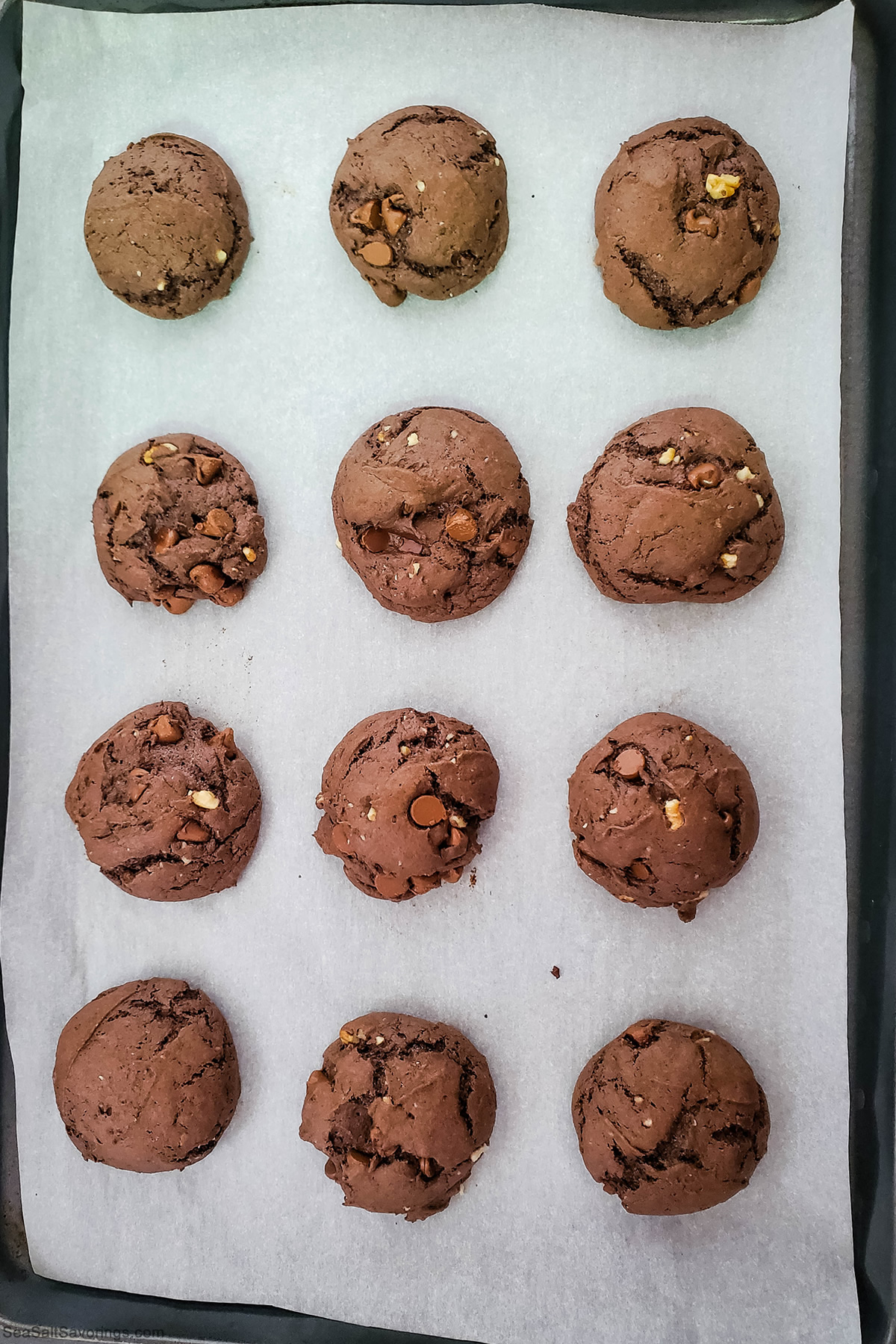 baking sheet lined with paper and freshly baked cookies on top