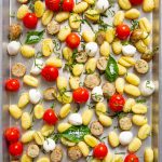 The gnocchi, tomatoes, and sausage is roasted on a sheet pan, then topped with fresh basil.