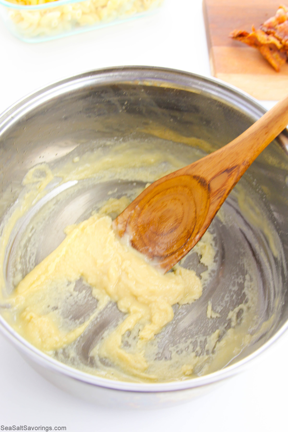 stirring cheese sauce base in a pot