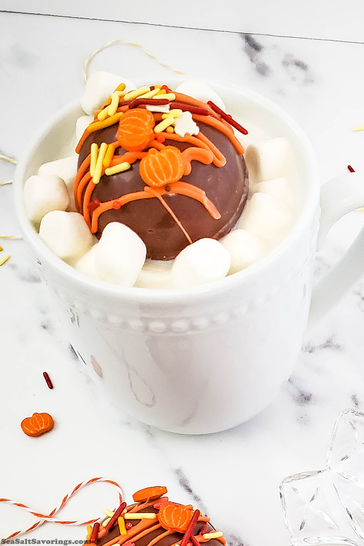 coffee mug with a cocoa bomb placed on top