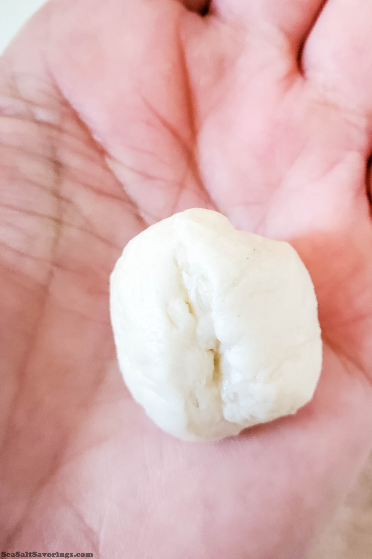 rolling piece of dough in hand to make a ball