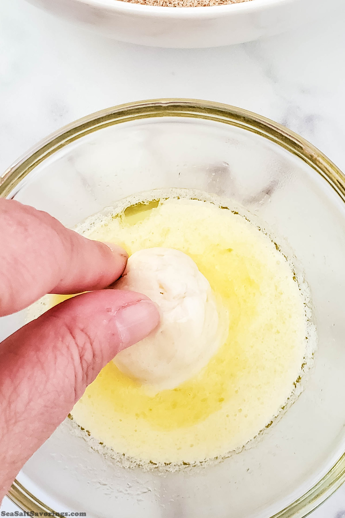 dipping dough ball into melted butter