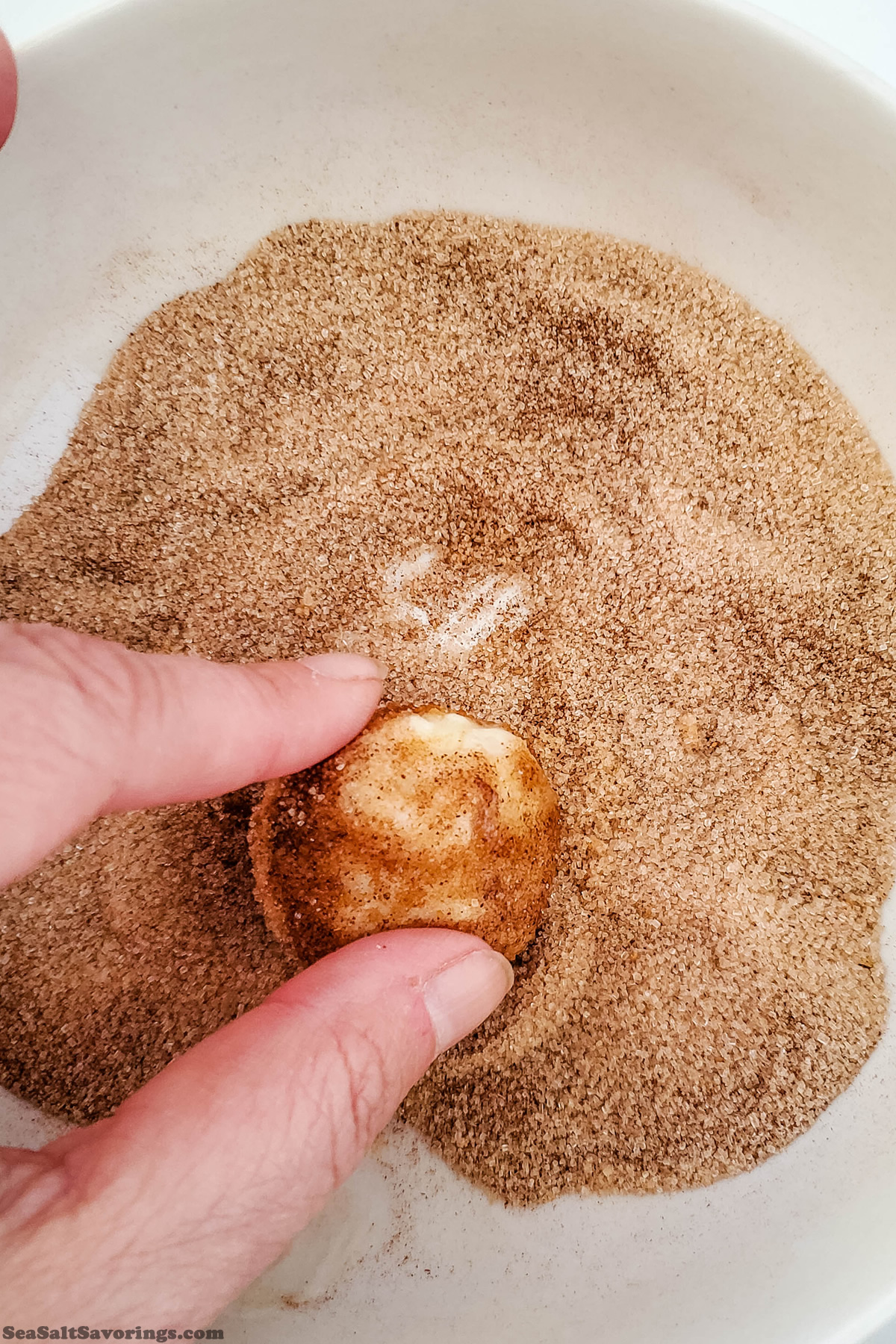 rolling buttered dough ball in seasoning mixture