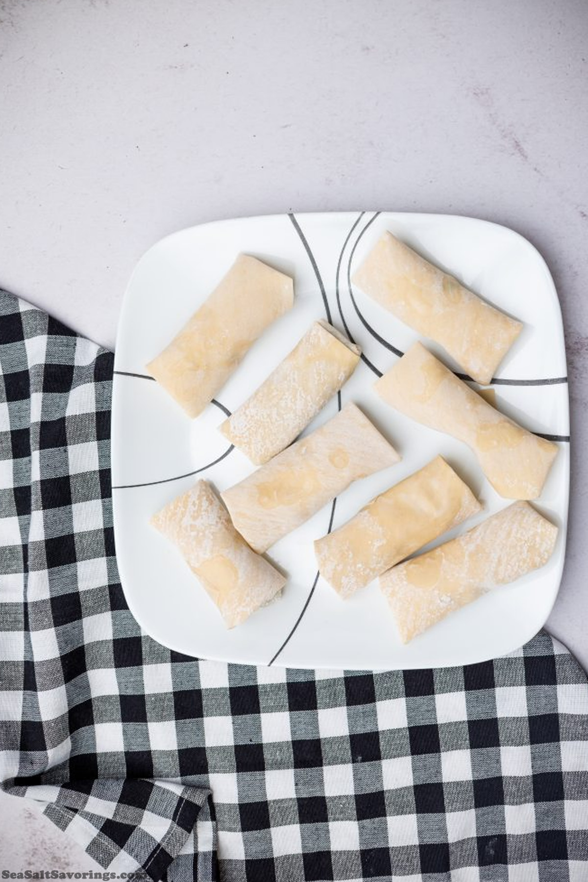 plate of uncooked eggrolls waiting to be cooked