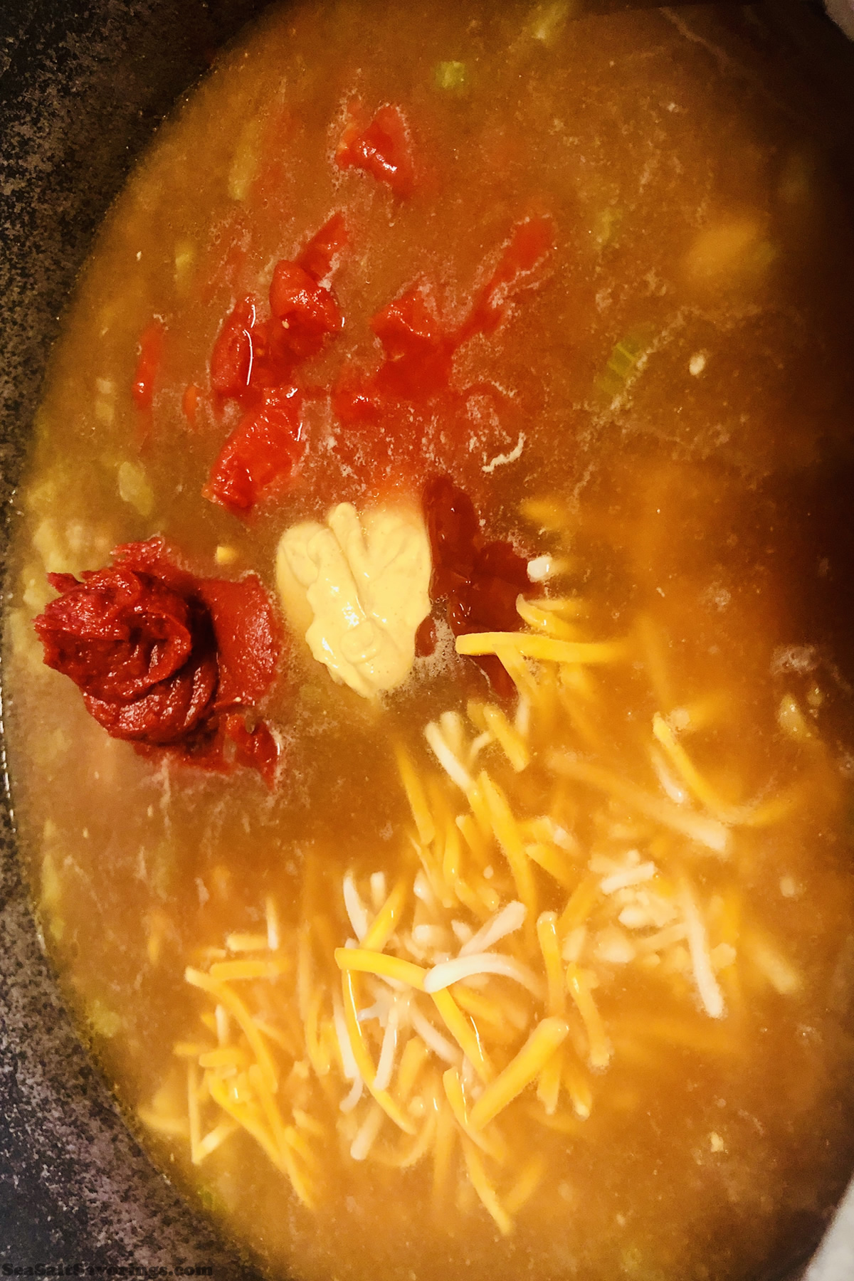 adding tomato paste to soup base