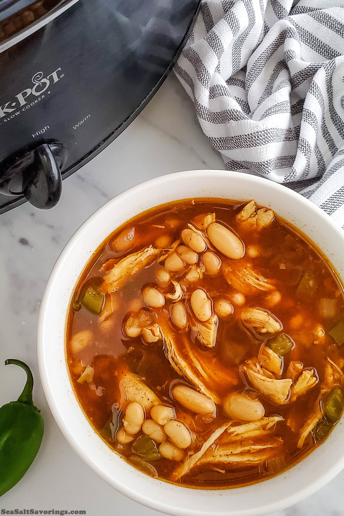 bowl of soup next to a crock pot