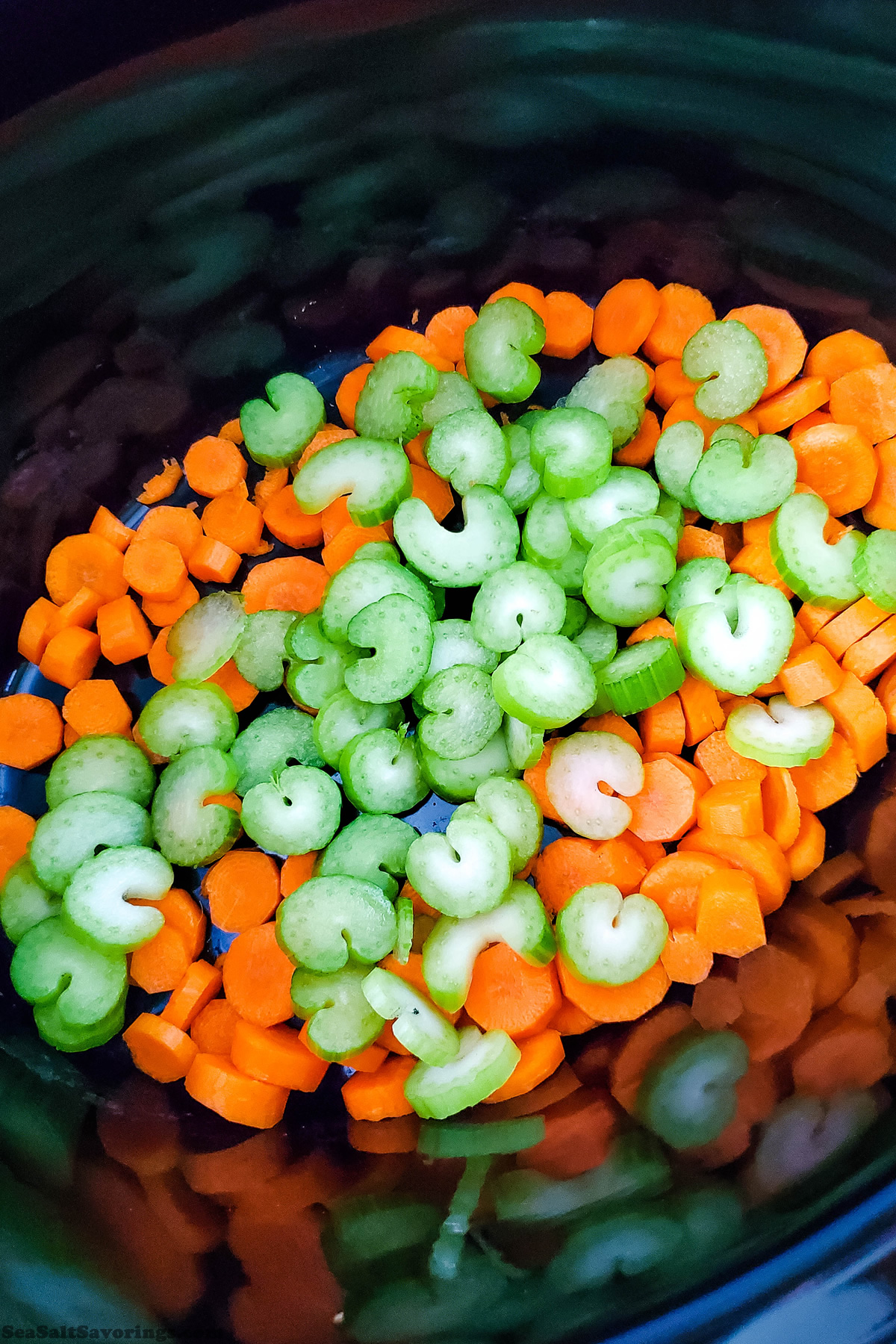 adding chopped carrots and celery to crock pot