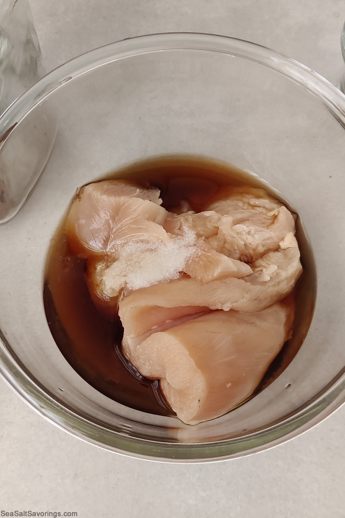 chicken marinating in a bowl